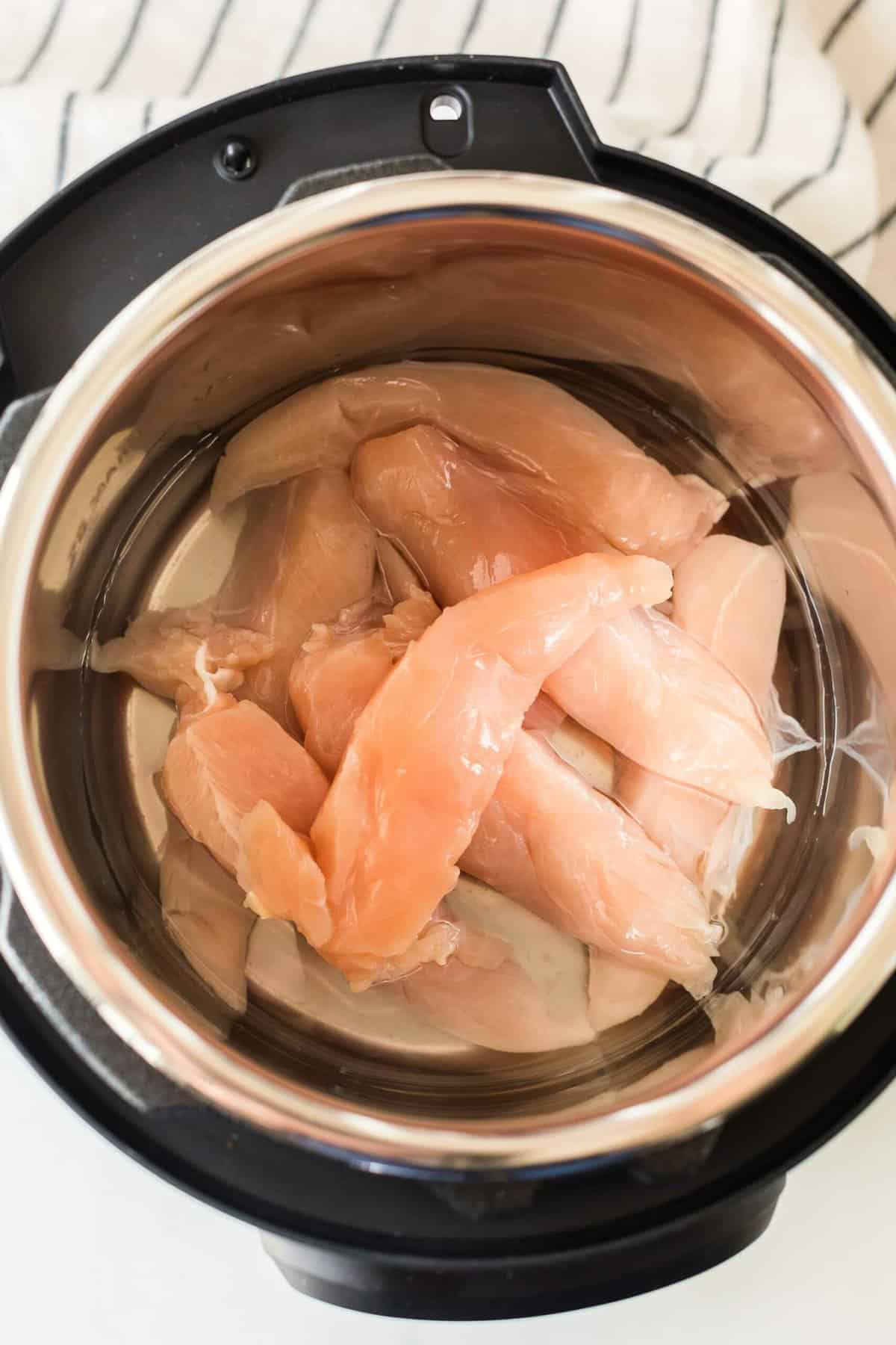 raw chicken in a pot of water ready to be cooked
