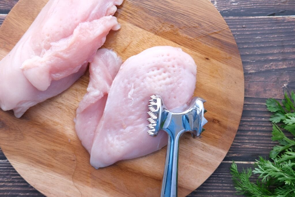 Tenderizing Raw Chicken Breast with a Meat Mallet 