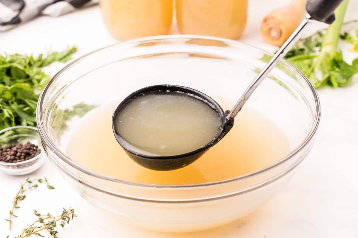 homemade chicken broth recipe in a bowl with a ladel